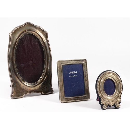 21 - An oval silver photograph frame, Chester 1917, 19 x 11.5cm and two other silver mounted frames (3).