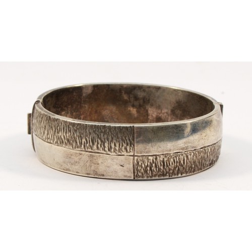 196 - A silver hinged bangle, Birmingham 1975, with textured decoration 61 x 58mm, 19mm wide, 49gm