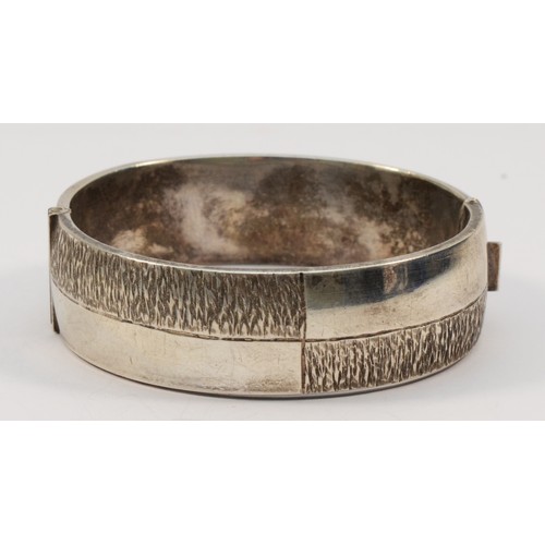 196 - A silver hinged bangle, Birmingham 1975, with textured decoration 61 x 58mm, 19mm wide, 49gm