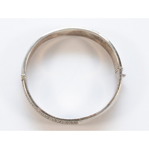 196 - A silver hinged bangle, Birmingham 1975, with textured decoration 61 x 58mm, 19mm wide, 49gm