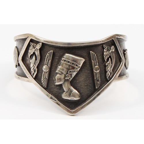 212 - An Egyptian silver bangle with various motifs, bearing control marks, 52gm