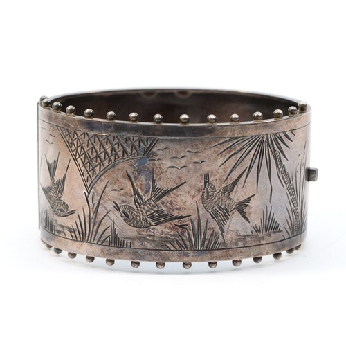 213 - A Victorian silver hinged bangle, Birmingham 1884, with engraved Aesthetic Movement bird decoration,... 