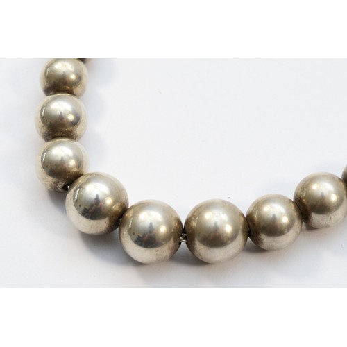 216 - Tiffany & Co. a silver bead necklace, 10 - 5mm diameter, length 40cm, 29gm