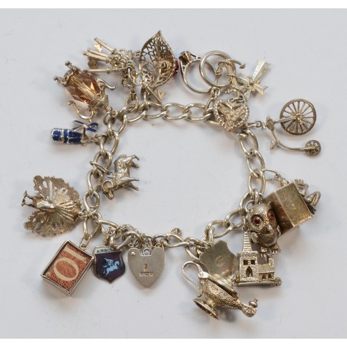 225 - A silver charm bracelet, including a £1 note and 10 Shilling note, 57gm