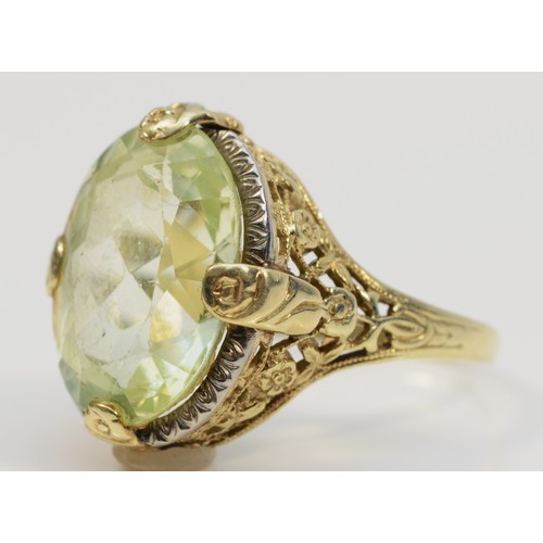 253 - A 14K gold Art Deco style green gemstone dress ring with a floral patterned mount, P, 5.7g