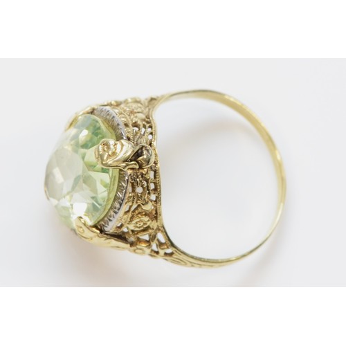 253 - A 14K gold Art Deco style green gemstone dress ring with a floral patterned mount, P, 5.7g