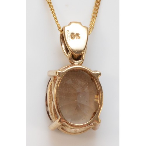 277 - A 9ct gold oval cut smokey quartz and diamond pendant with necklace, 17mm pendant length, 3g