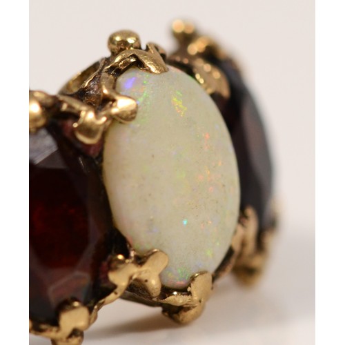 317 - A 9ct gold vintage opal and garnet three stone ring, with patterned shoulders, O 1/2, 2.9g