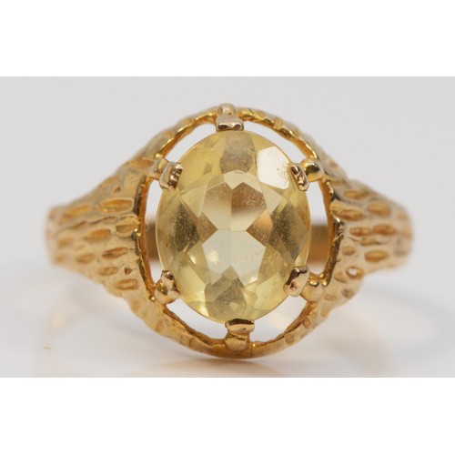 324 - A 9ct gold vintage oval cut citrine dress ring with a bark effect pattern, Q, 2.4g