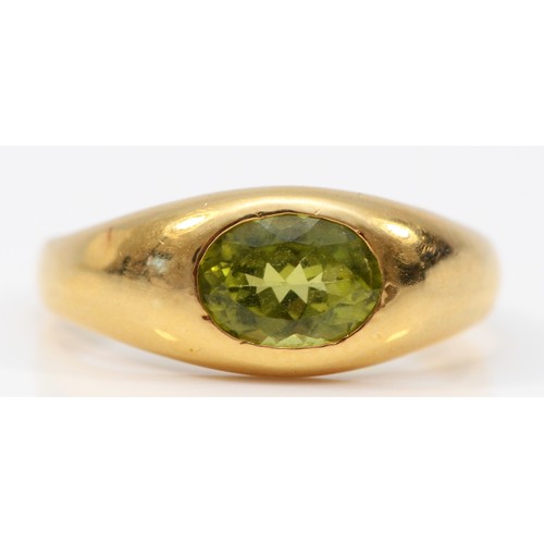 348 - A 14K gold oval cut peridot dress ring, bezel set, Q, 2.6g