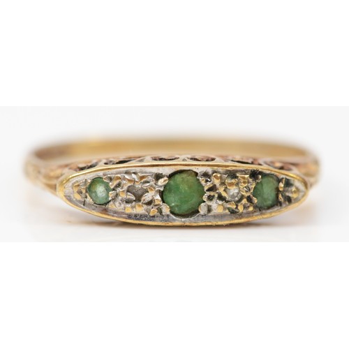 368 - A 9ct gold vintage oval cut emerald and diamond ring with a scroll patterned gallery, O, 1.5g