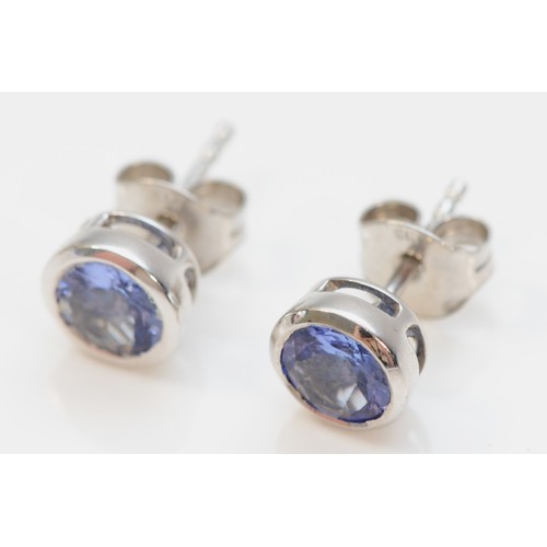 375 - A pair of 9ct gold tanzanite stud earrings, bezel set with scroll backs, 6mm diameter, 1.6g