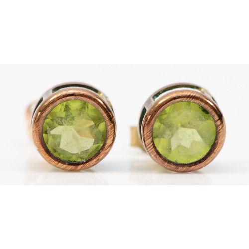 385 - A pair of 9ct gold bezel set peridot stud earrings with scroll backs, 5mm diameter, 0.9g