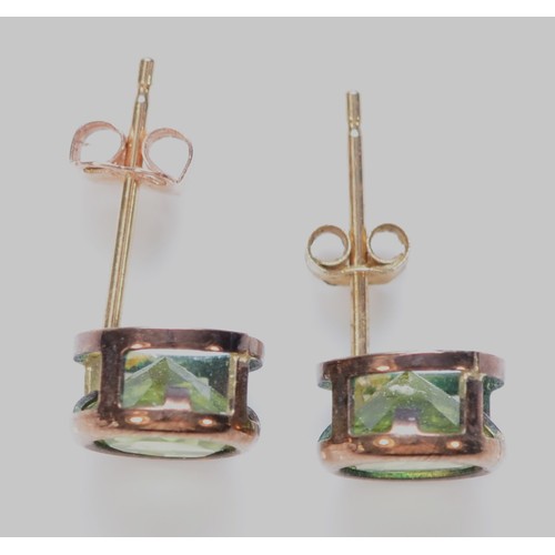 385 - A pair of 9ct gold bezel set peridot stud earrings with scroll backs, 5mm diameter, 0.9g