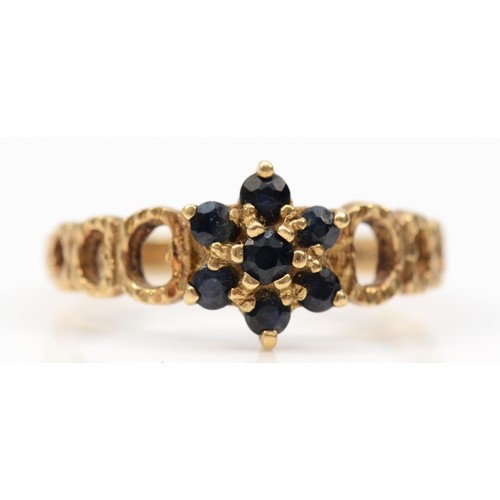 560 - A 9ct gold sapphire cluster ring with bark effect shoulders, London 1976, M, 2g