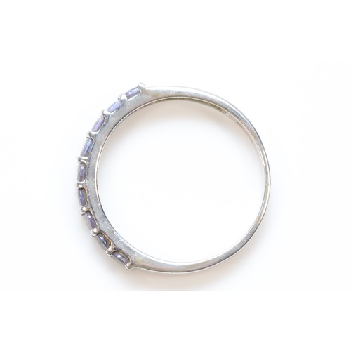 585 - A 9ct white gold tanzanite half eternity ring, claw set, N 1/2, 1.5g