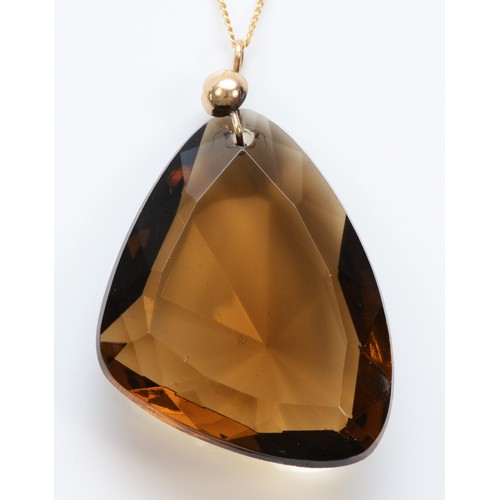 595 - A 9ct gold fancy cut smokey coloured paste pendant with chain, 38mm length, 13.6g