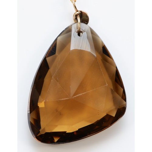 595 - A 9ct gold fancy cut smokey coloured paste pendant with chain, 38mm length, 13.6g