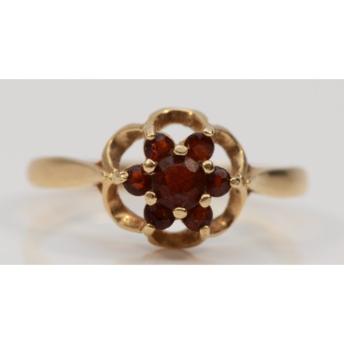 600 - A 9ct gold garnet floral dress ring, L 1/2, 1.7g