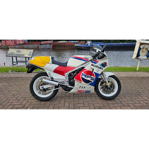 1987 Suzuki RG500, 498cc. Registration number E580 AUF. Frame number HM31A 106195. Engine number M301107211.
Sold with the V5C, a purchase receipt dated 2002 for £650!
Derived from Suzuki’s 500cc RG Gamma XR45 factory Grand Prix racer, the Suzuki RG500 was a road-legal replica racer produced between 1985 and 1987.
Barry Sheene achieved back-to-back 500cc championship titles in 1976 and 1977 before the Gallina Suzuki team repeated the feat five years later with riders Marco Lucchinelli and Franco Uncini in 1981 and 1982.
To capitalize on their reputation Suzuki decided to develop a production version of its competition square-four machine based on the XR45’s race-bred 130 hp unit.
The engine produced 95 hp at 9,500rpm and 53ft-lbs of torque at 8,000rpm. Weighing in at just 340lbs dry, the RG500 offered a top speed of over 130mph and could achieve quarter-mile runs in 11-seconds. The engine had rotary valves and twin-cranks, it featured Mikuni 28mm flat-side carbs, an exhaust utilizing SAEC (Suzuki Automatic Exhaust Control), a six-speed cassette-style gearbox and thermostatically controlled liquid-cooling.
AUF is painted in the Pepsi scheme from the 1988 and 1989 seasons. 1989 was also one of the best seasons for lead rider, Kevin Schwantz, who was placed either first or second in every race he finished that season, taking six wins and a further three runner-up finishes. 
AUF was owned by Wain Hardy from 1999 until 2002 when Liam bought it selling it to our vendor four months later. At this time the engine was stated to be in excellent order, having had some unspecified work done on it. It has been in storage since and will require recommissioning.