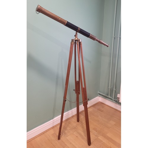 23 - A reproduction brass drawer telescope, replicating a 19th century example, mounted on a mahogany adj... 