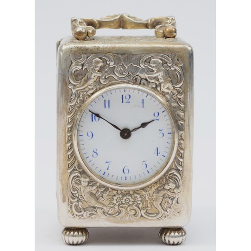 13 - A Victorian silver desk time piece, by William Comyns, London 1896, with embossed cherub and scroll ... 