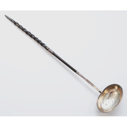 29 - A George III silver and whalebone ladle, London 1972, with bright cut engraved decoration, 38cm