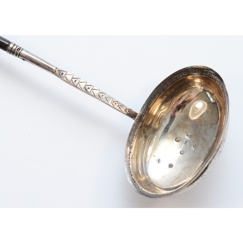 29 - A George III silver and whalebone ladle, London 1972, with bright cut engraved decoration, 38cm