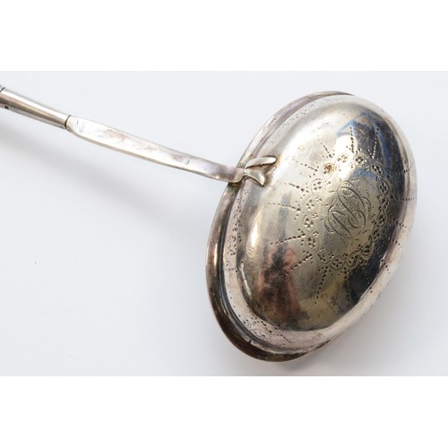 29 - A George III silver and whalebone ladle, London 1972, with bright cut engraved decoration, 38cm