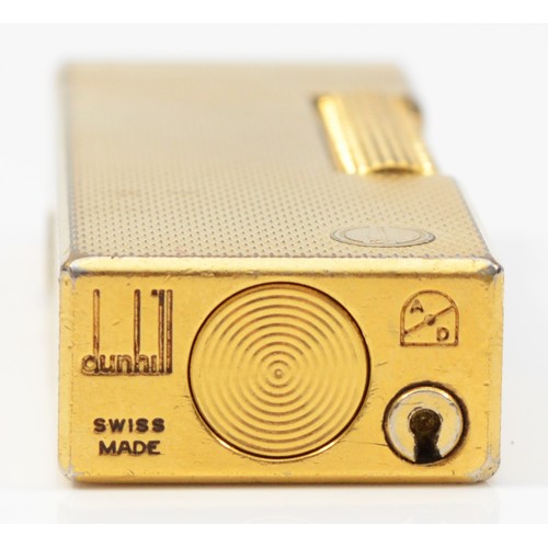 64 - Dunhill, a gold plated rollagas lighter, no serial number, case and box.