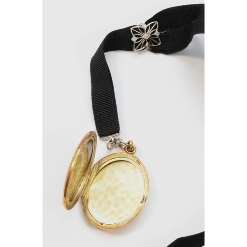 73 - An American late 19th century 14K gold, black enamel and pearl locket, opening to reveal two compart... 