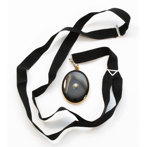 73 - An American late 19th century 14K gold, black enamel and pearl locket, opening to reveal two compart... 