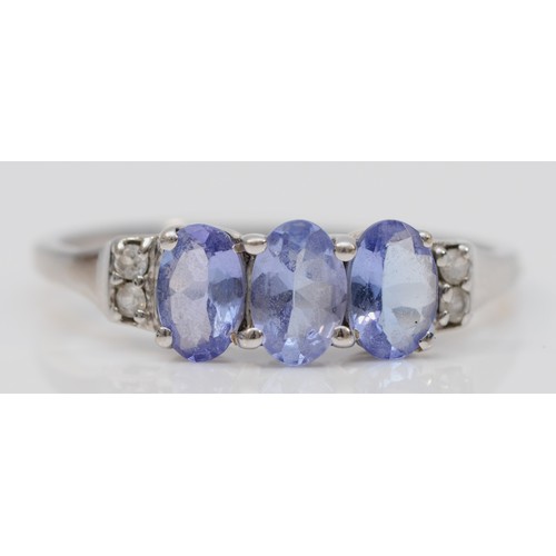 97 - A 9ct white gold oval cut tanzanite dress ring, three tanzanite stones, diamonds on the shoulders, S... 