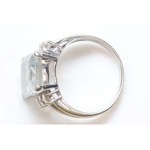 143 - A 9ct white gold aquamarine and white gemstone dress ring, 12mm x 10mm aquamarine, N, 4.5g