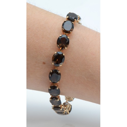 151 - A 9ct gold oval cut smokey quartz bracelet, 18cm, 15g