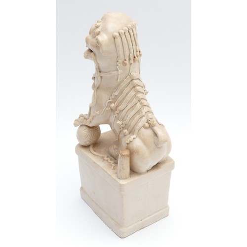 323 - A Chinese blanc de chine figure of a Dog of Fo, late 19th/early 20th century, modelled seated with i... 