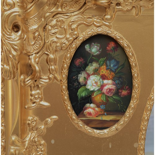 384 - A gilt wall mirror, with central oval bevelled panel surrounded by four oval painted floral still li... 