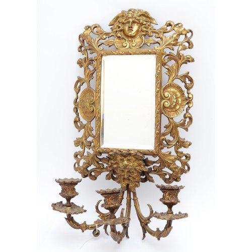 386 - A 20th century cast brass three light wall mirror, with masks above and below, lacking wiring, 60 x ... 