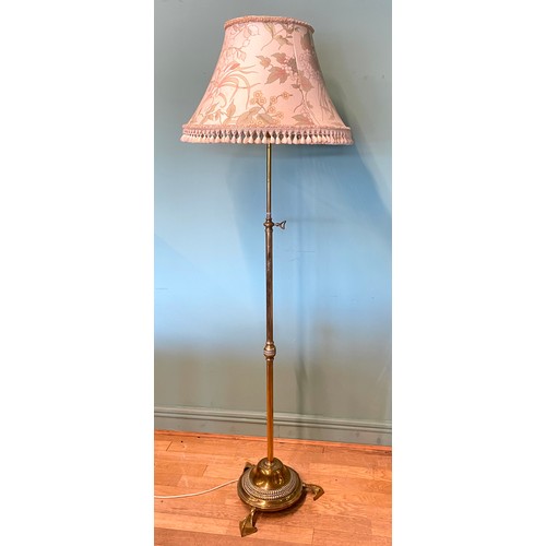 387 - An Edwardian brass rise adjustable standard lamp, with cast iron base, raised on three pad feet, 140... 