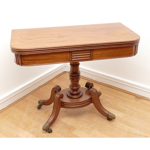 435 - A Victorian mahogany fold over games table, with baize insert, raised on a turned pedestal with quat... 