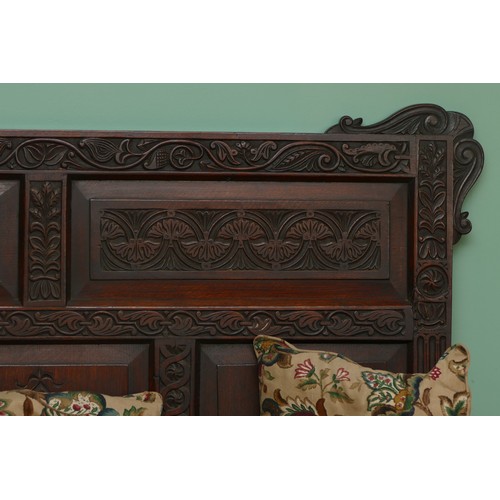 457 - A late 19th century oak box settle, the lunette carved frieze over five panels incised with foliate ... 