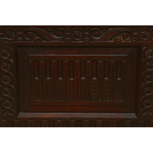 457 - A late 19th century oak box settle, the lunette carved frieze over five panels incised with foliate ... 