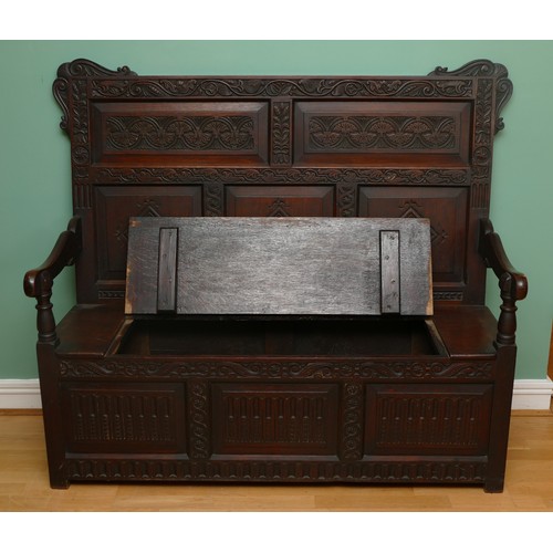 457 - A late 19th century oak box settle, the lunette carved frieze over five panels incised with foliate ... 