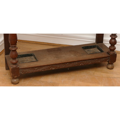 456 - An early 20th century Jacobean revival oak hall stand, the carved stepped pediment over rectangular ... 