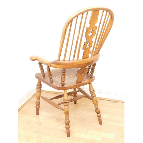 444 - An early 20th century beech and elm high back windsor armchair, the hooped backrest with pierced spl... 