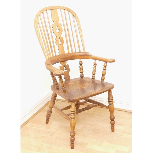 444 - An early 20th century beech and elm high back windsor armchair, the hooped backrest with pierced spl... 