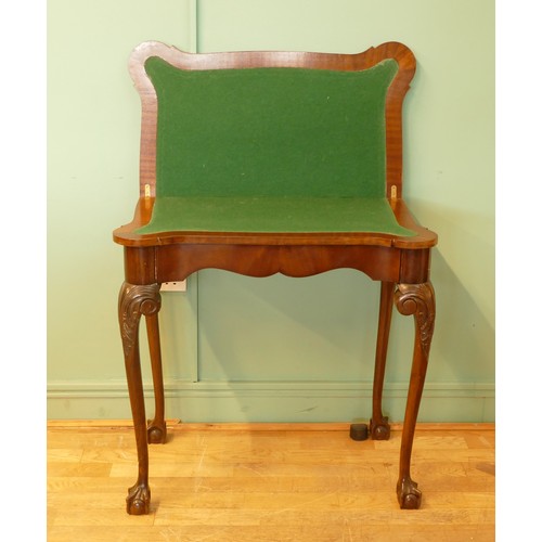 449 - An Edwardian mahogany fold over games table, with baize cover and leaf capped with ball and claw fee... 