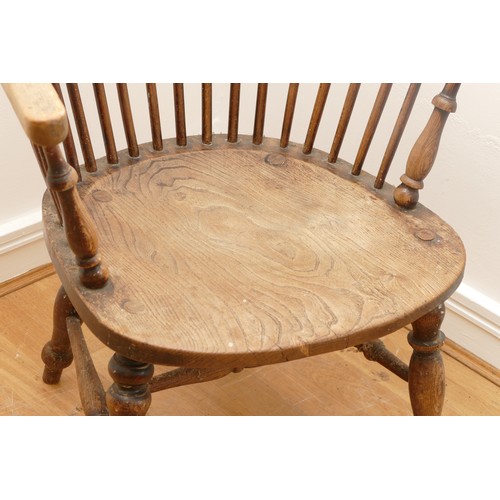 462 - A late 19th century oak and elm windsor chair, having stick and hoop back, outswept armrests support... 