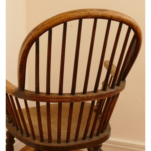 462 - A late 19th century oak and elm windsor chair, having stick and hoop back, outswept armrests support... 