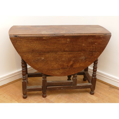 463 - A late 18th century oak gateleg dining table, the extending planked top of oval form, raised on turn... 